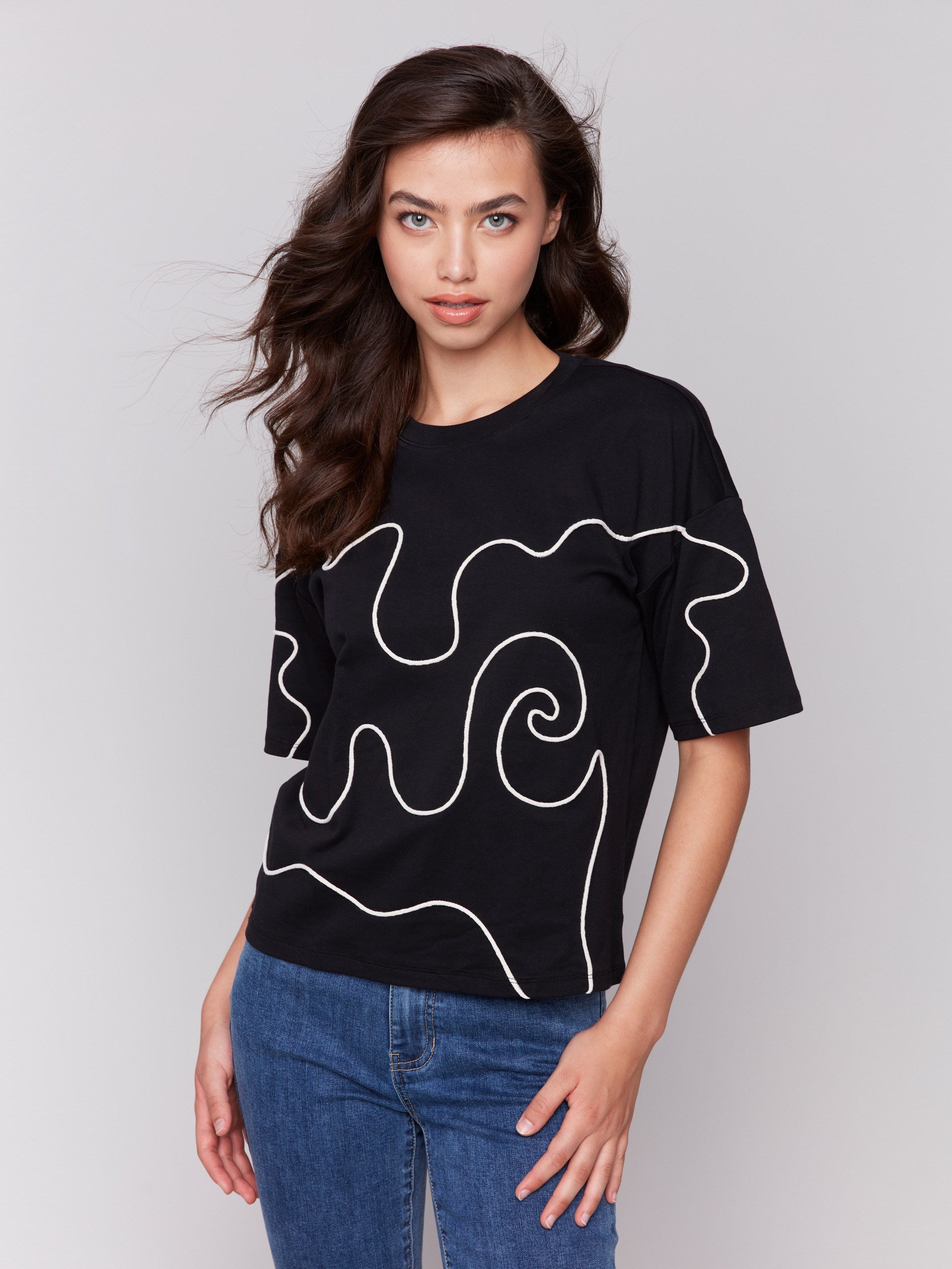 Black t-shirt with drop shoulder design, featuring white soutache detailing by Charlie B.