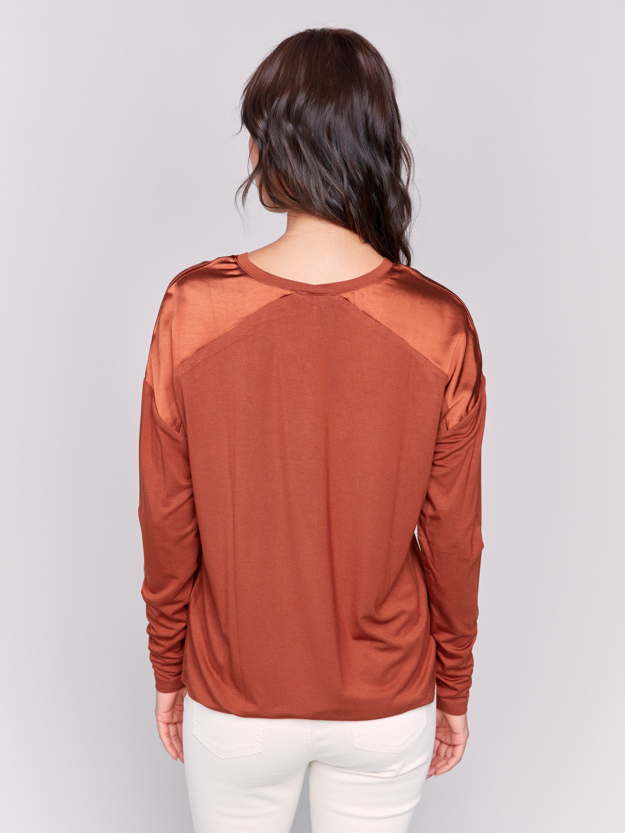 Terracotta satin and jersey top featuring V-neck design and long sleeves by Charlie B.