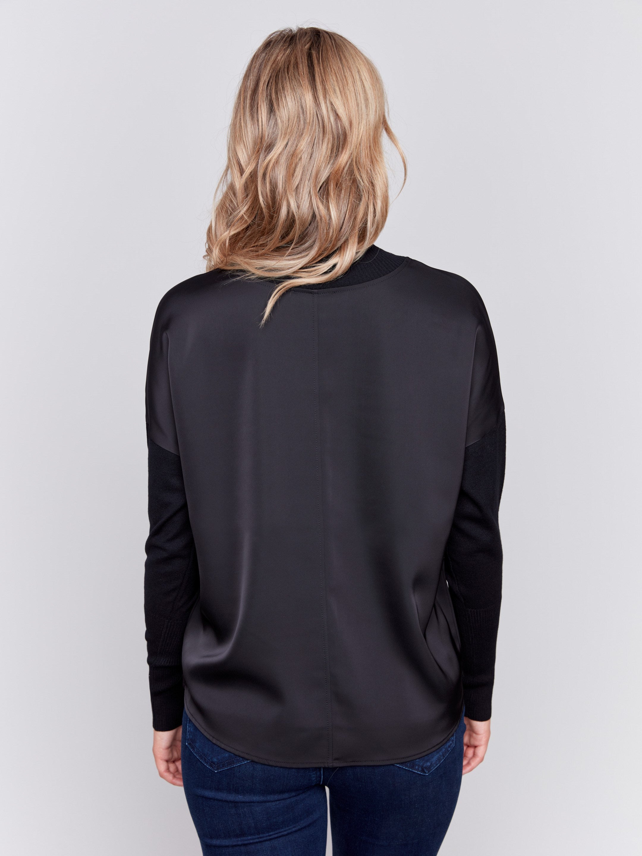 Black satin-knit top with a mock neck and front seam detail, featuring long sleeves and ribbed cuffs by Charlie B.