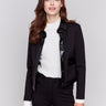 Short black jacket with glossy vinyl trim, featuring front flap pockets and a button closure, by Charlie B.