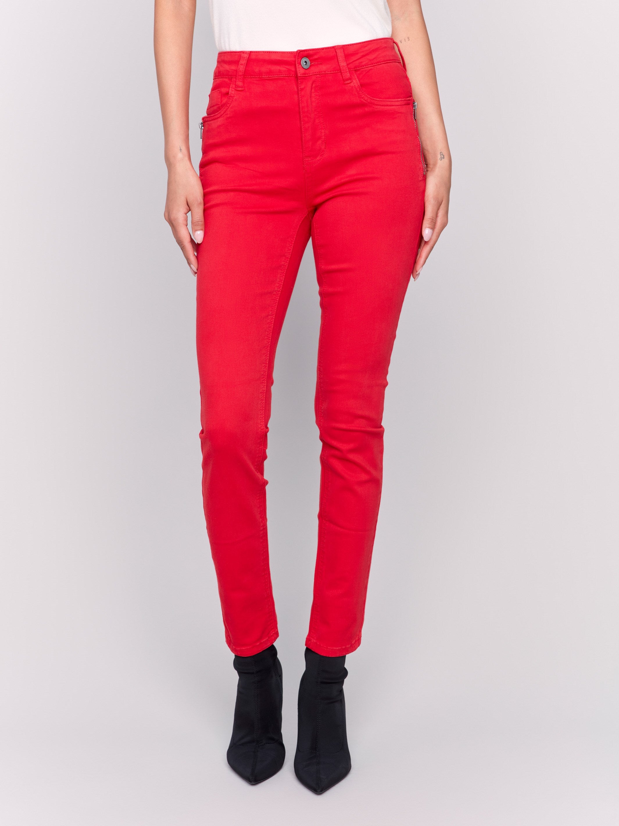 Cranberry red skinny twill pants with a mid-rise waist, skinny fit, and side zipper pocket details by Charlie B.