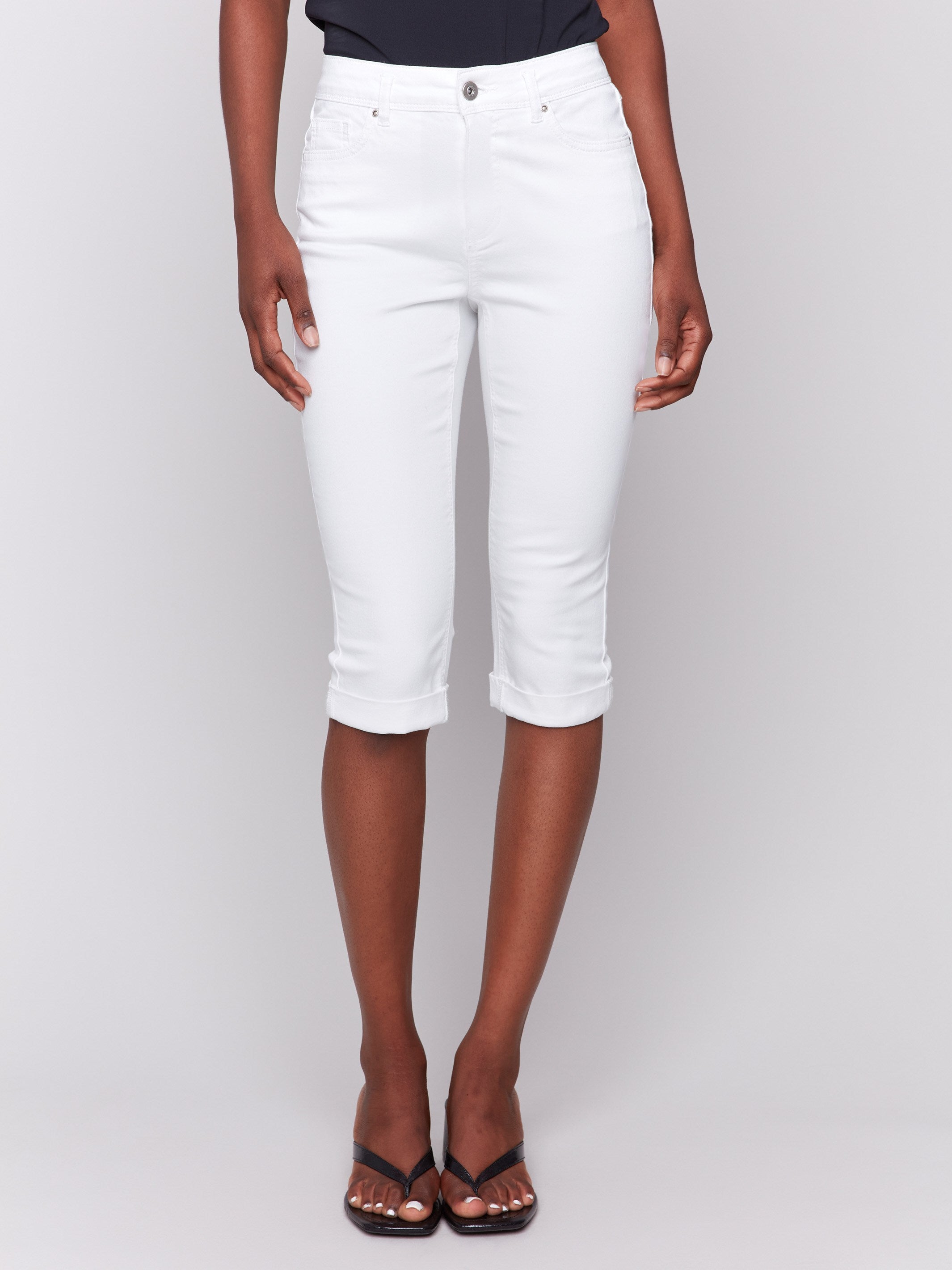 White pedal pusher pants featuring a slim fit and mid-rise waist by Charlie B.