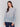 Grey knit sweater with blue floral embroidery along the hem and sleeves, featuring a crew neckline by Charlie B.