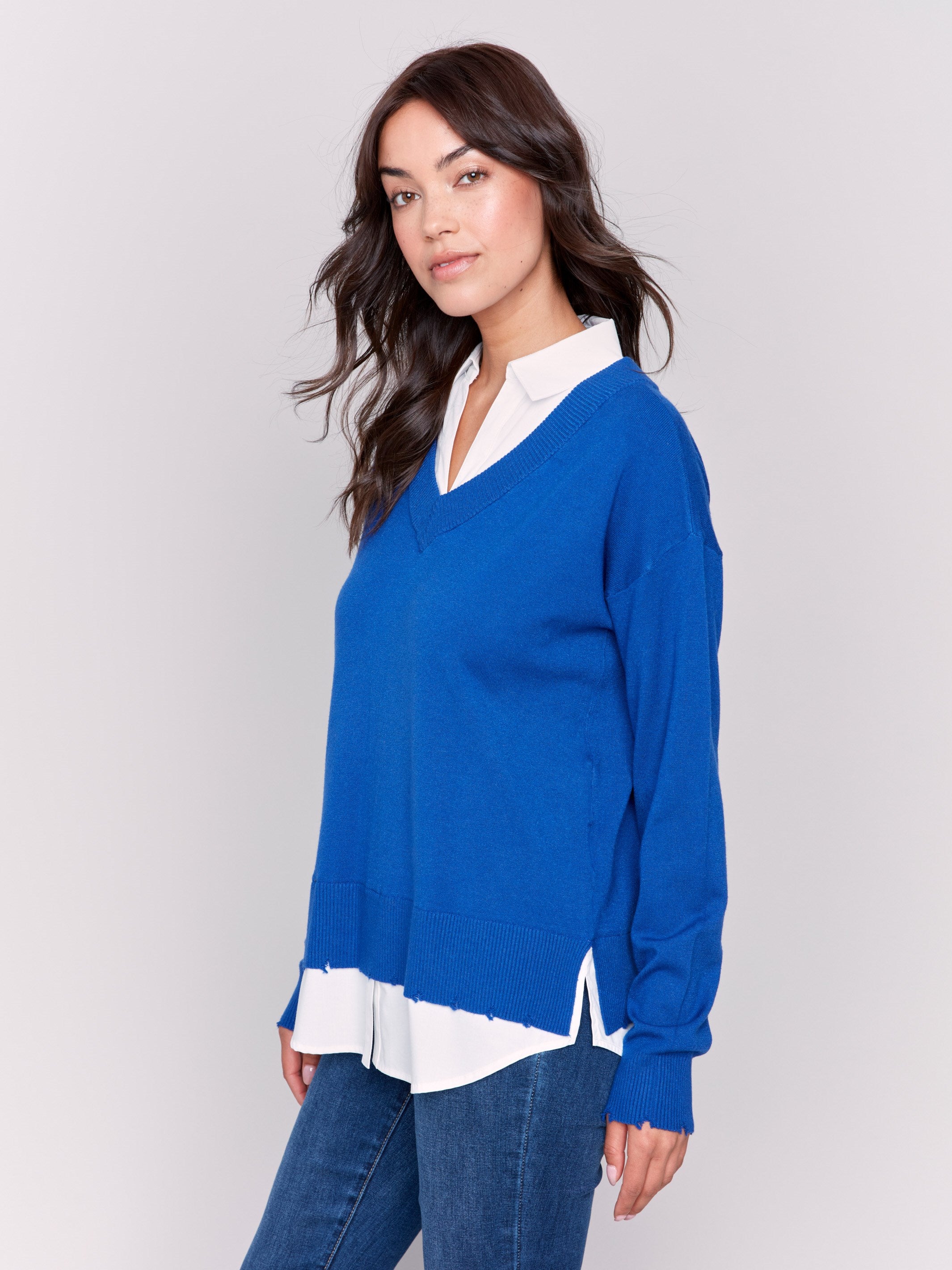 Sapphire V-neck fooler sweater with white shirt collar, featuring a shirttail hem and side slits by Charlie B.