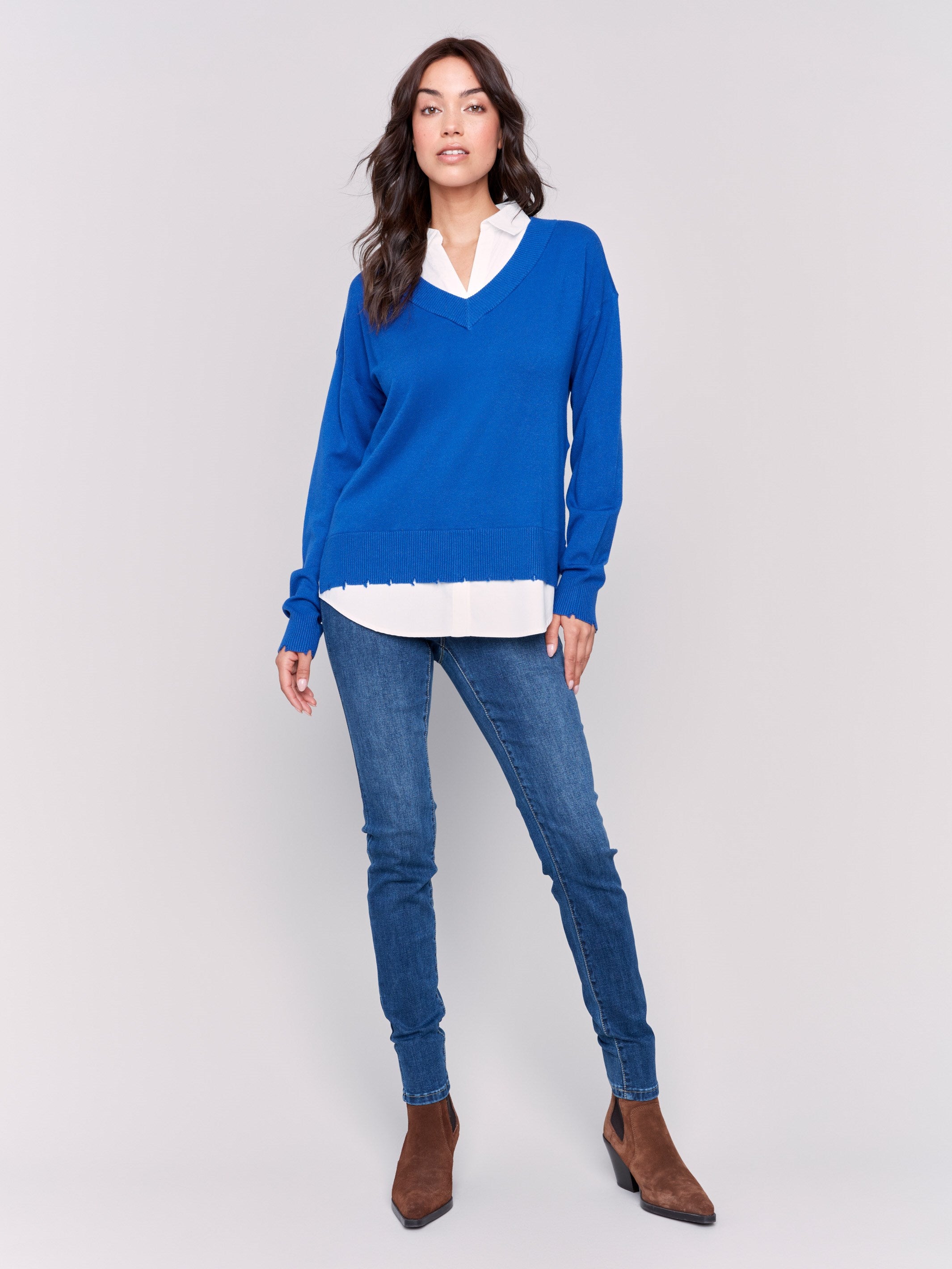 Sapphire V-neck fooler sweater with white shirt collar, featuring a shirttail hem and side slits by Charlie B.