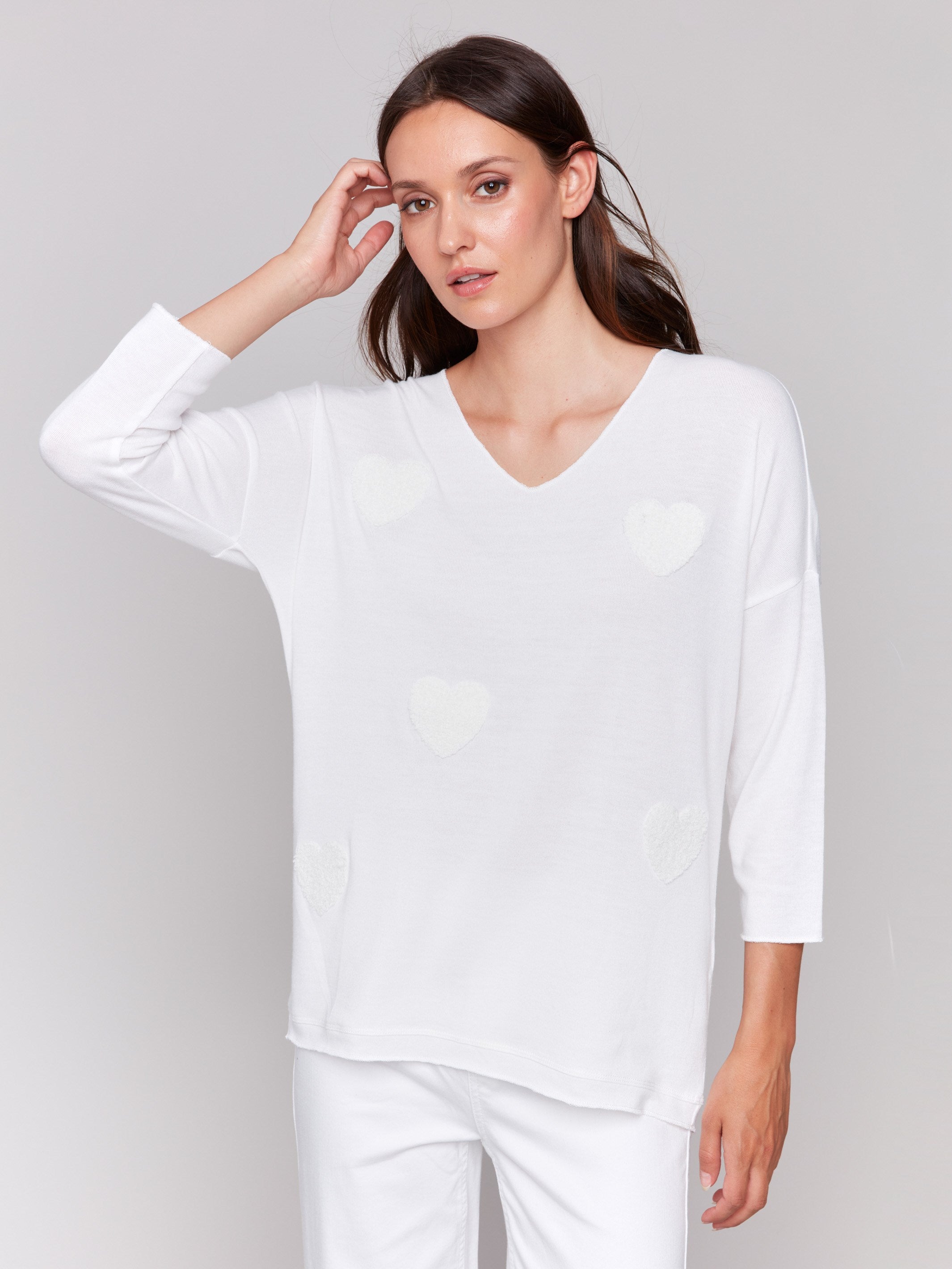 White V-neck knit top with heart appliqués, featuring drop shoulders, by Charlie B.