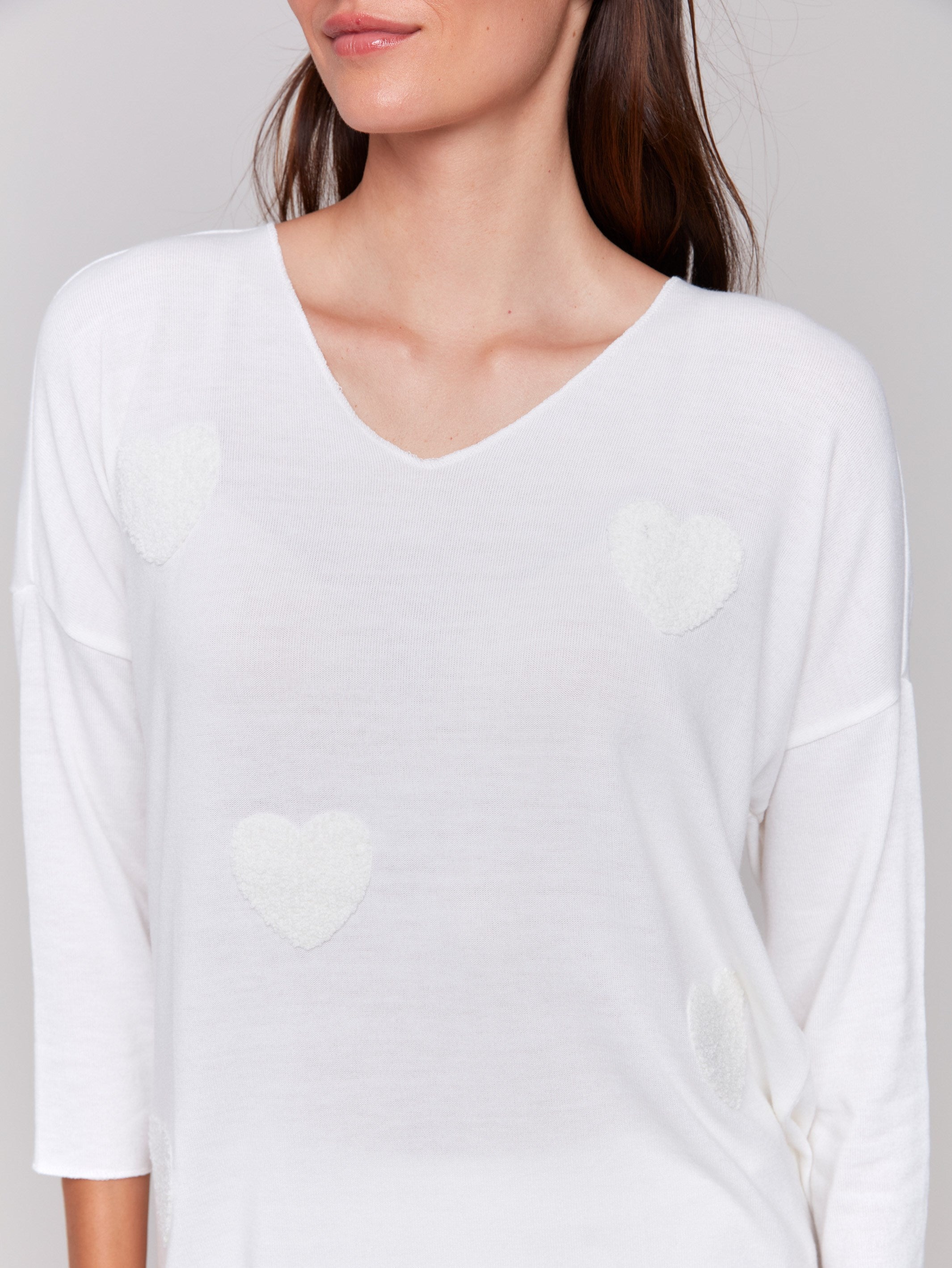 White V-neck knit top with heart appliqués, featuring drop shoulders, by Charlie B.