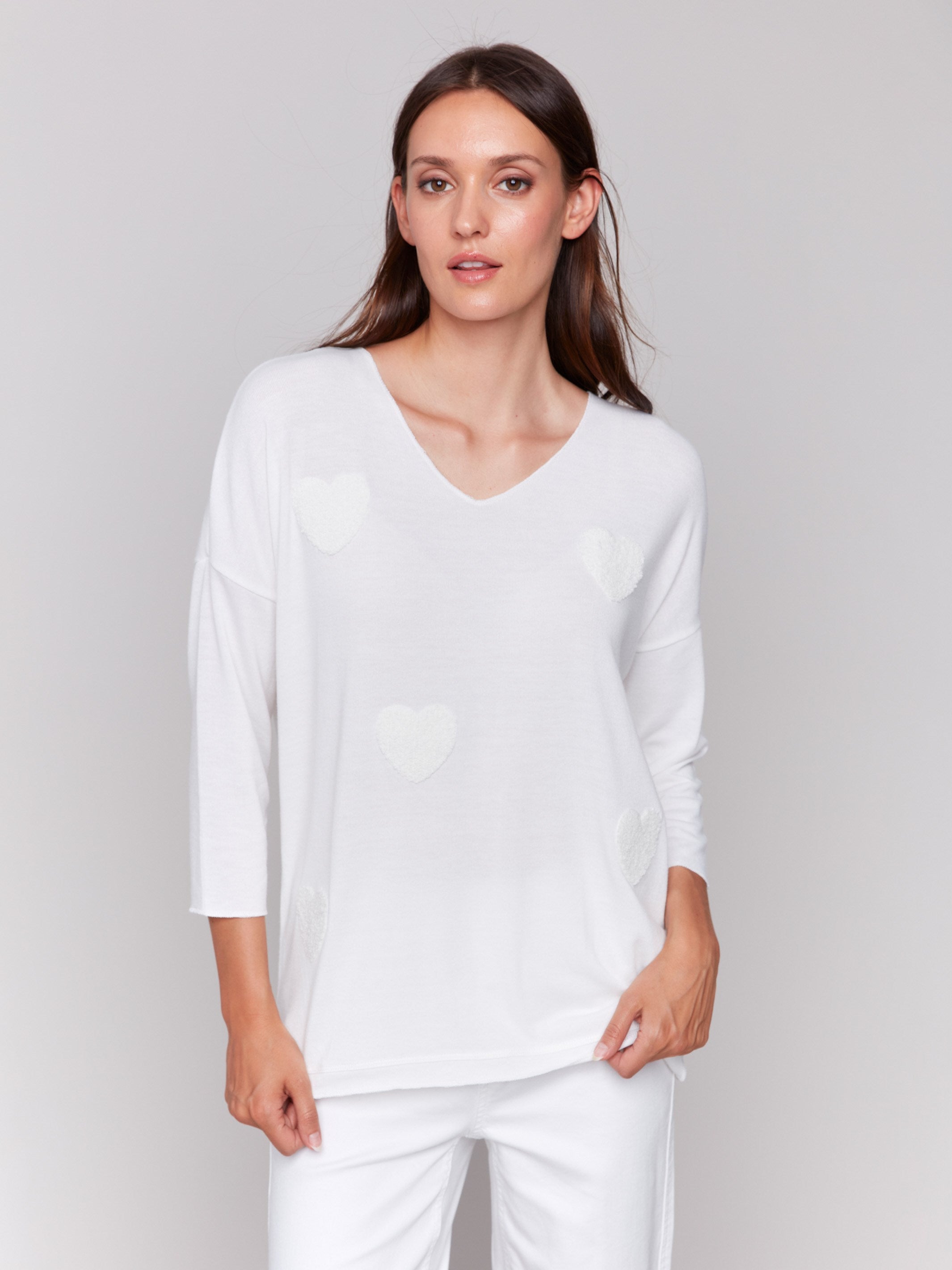 White V-neck knit top with heart appliqués, featuring drop shoulders, by Charlie B.